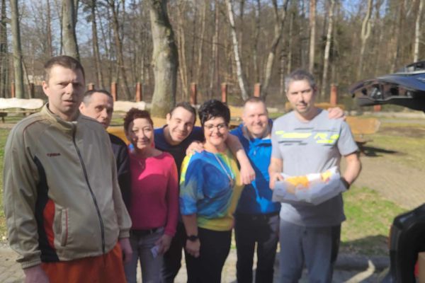 Mieszkańcy odebierają dary z samochodu. Grupowe zdjęcie przy aucie.