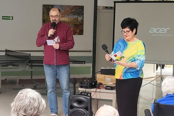 Pani Dyrektor czyta życzenia Mieszkańcom zgromadzonym na holu domu.