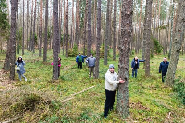 Mieszkańcy stoją przy drzewach w lesie.