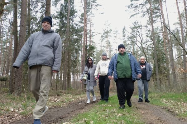 Mieszkańcy ida ścieżką leśną.
