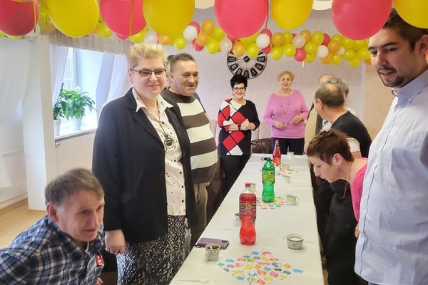 Mieszkańcy i pracownicy wznoszą toast.