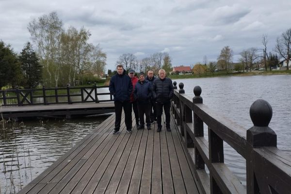Pięcioro mieszkańców nad jeziorkiem na pomoście.