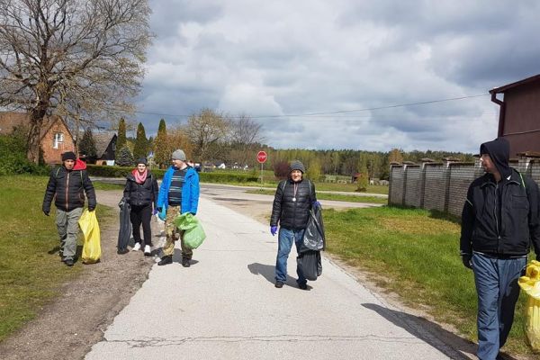Kilkoro mieszkańców sprząta miejscowość.