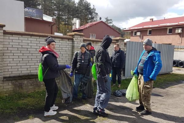 Kilkoro mieszkańców sprząta miejscowość.