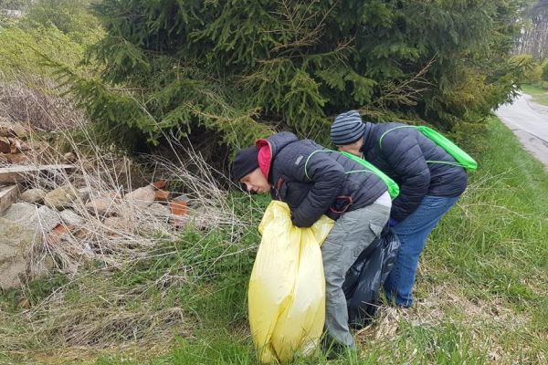 Dwoje mieszkańców sprząta miejscowość.