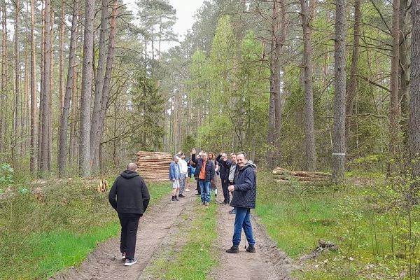Mieszkańcy idą ścieżką leśną.