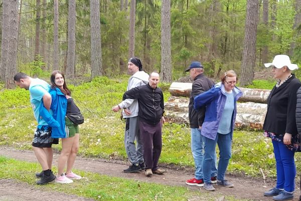 Mieszkańcy wykonują drobne ćwiczenia gimnastyczne w środku lasu.