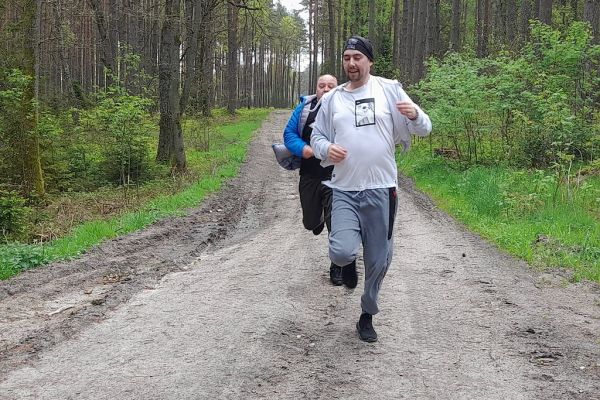 Mieszkańcy biegną przez las.