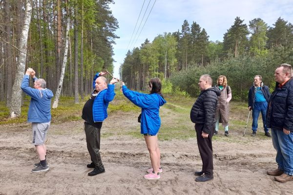 Mieszkańcy wykonują drobne ćwiczenia gimnastyczne w środku lasu.
