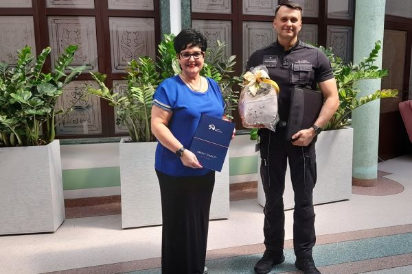 Pani Dyrektor Domu i Pan Dyrektor Aresztu na holu domu trzymaja porozumienie współpracy.