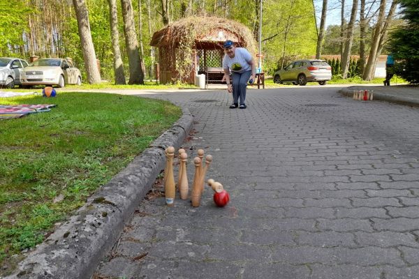 Mieszkaniec gra w kręgle na świeżym powietrzu.
