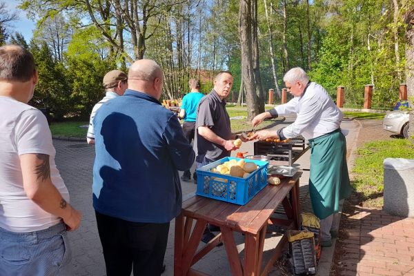 Mieszkańcy częstują się grillem.
