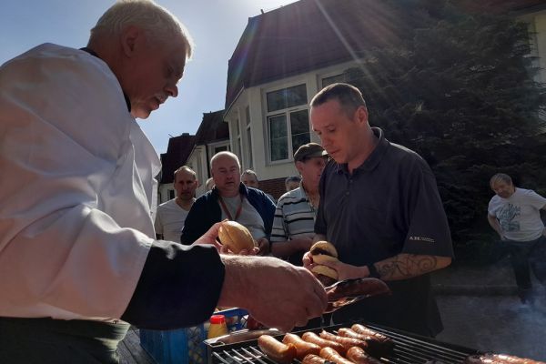 Mieszkańcy częstują się grillem.