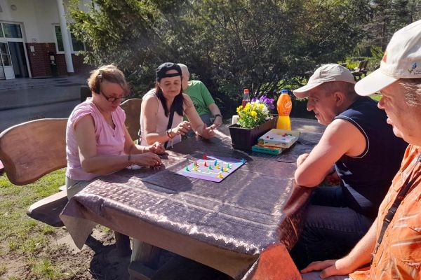 Mieszkańcy graja w chińczyka na świeżym powietrzu.