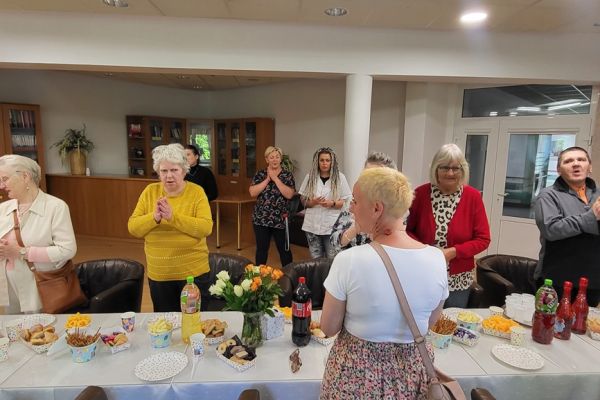 Mieszkańcy na stojąco śpiewają sto lat jubilatce.