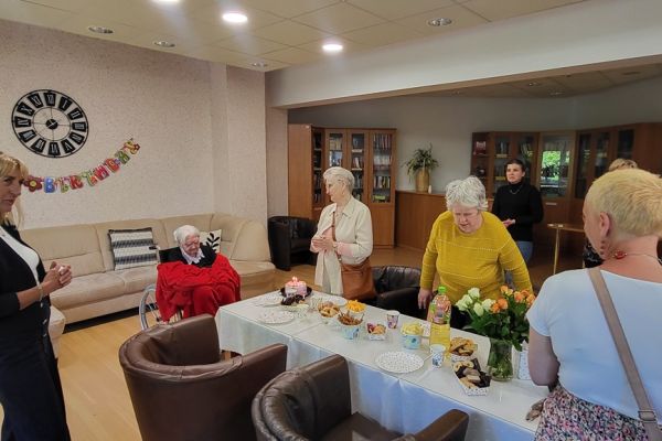 Mieszkańcy na stojąco śpiewają sto lat jubilatce.