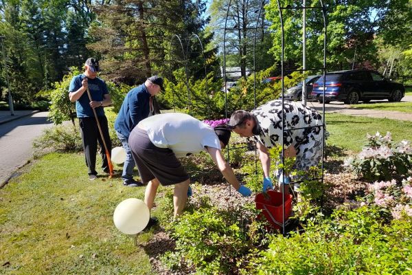 Mieszkańcy sprzątają kląb z kwiatami przy Domu.