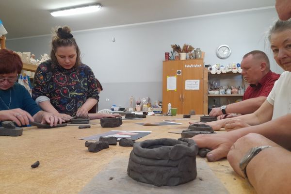 Mieszkańcy w pracowni lepią z gliny.