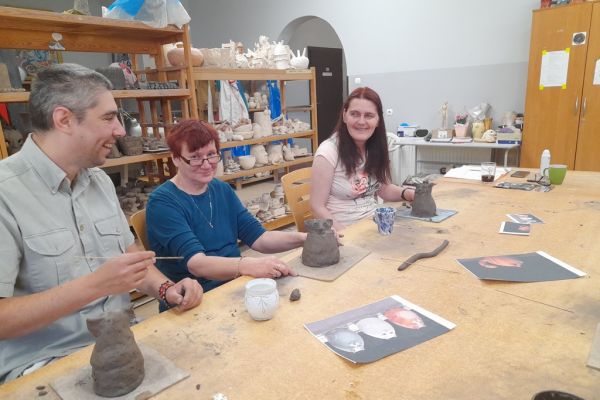 Mieszkańcy w pracowni lepią z gliny.