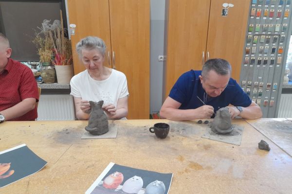 Mieszkańcy w pracowni lepią z gliny.