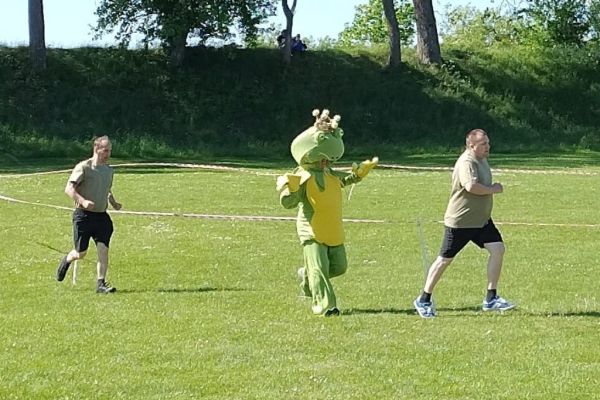 Mieszkańcy i żaba biegną.