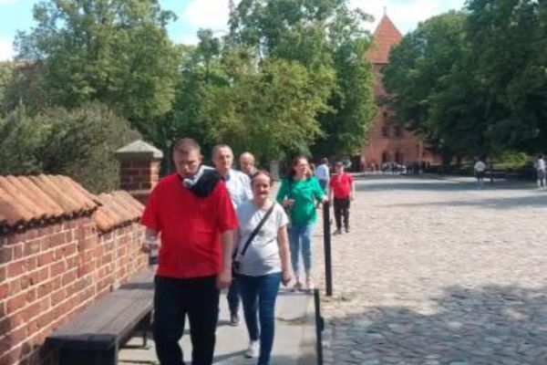 Grupka mieszkańców spaceruje alejami miasta Tczewa.