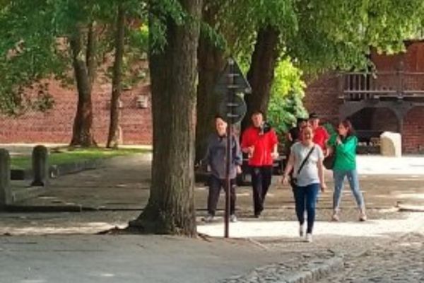 Grupka mieszkańców spaceruje alejami miasta Tczewa.