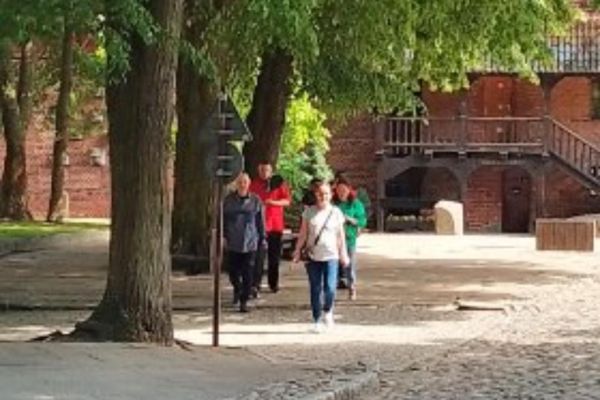 Grupka mieszkańców spaceruje alejami miasta Tczewa.