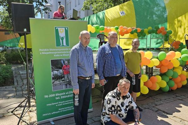 Zbiorowe zdjęcie czworo mieszkańców podczas dnia godności osób niepełnosprawnych w Słupsku.