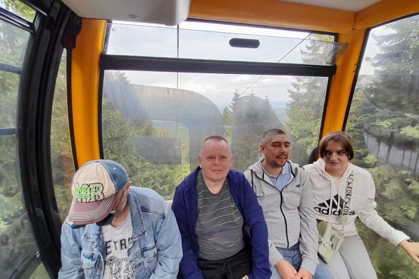 Mieszkańcy siedza w koleji gondolowej.