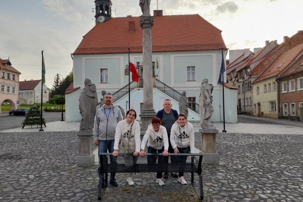 Mieszkańcy pozują przy ławeczce w Lubomierzu.