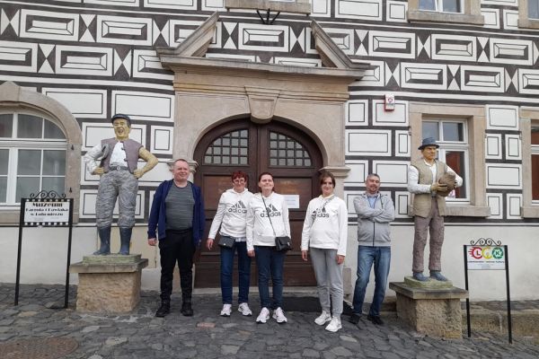 Zbiorowe zdjęcie mieszkańców przy figurach Kargula i Pawlaka.