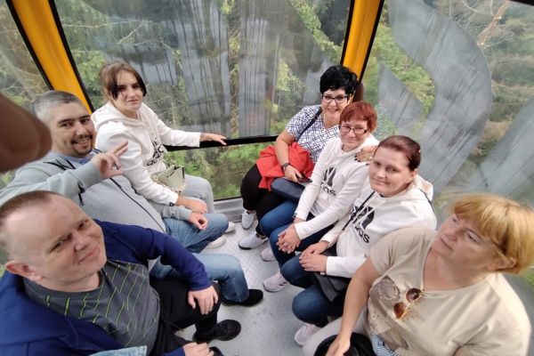 Mieszkańcy siedza w koleji gondolowej.