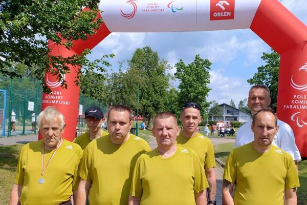 Zbiorowe zdjęcie sześciu mieszkańców na tle mety.