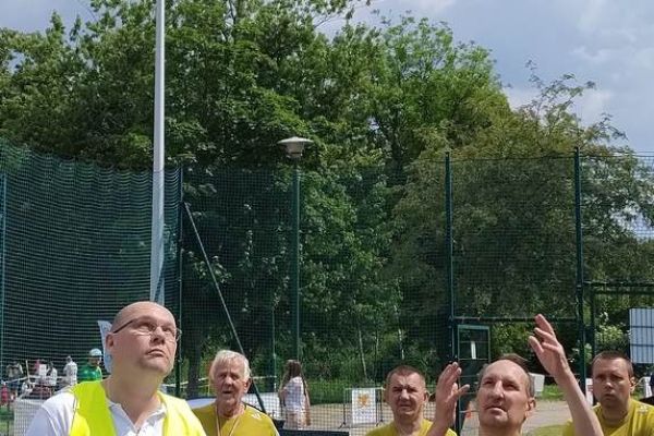 Mieszkaniec rzuca na zawodach sportowych , wokoło inni uczestnicy.