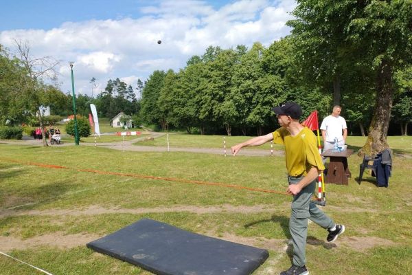 Mieszkaniec rzuca na zawodach sportowych , wokoło inni uczestnicy.