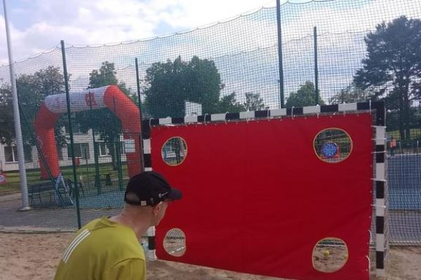 Mieszkaniec rzuca na zawodach sportowych , wokoło inni uczestnicy.