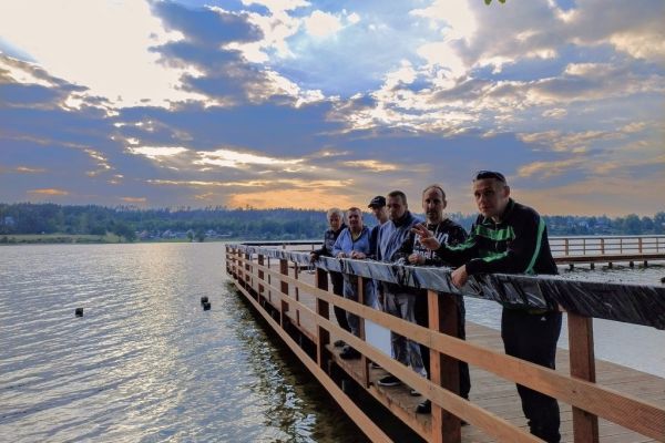 Mieszkańcy na pomoście nad jeziorem.