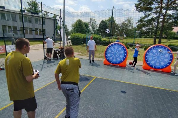 Mieszkaniec rzuca na zawodach sportowych , wokoło inni uczestnicy.