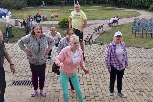 Uczestnicy pikniku tańczą na dworze.