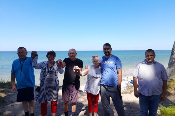 Mieszkańcy stoją przy klifie nad morzem.