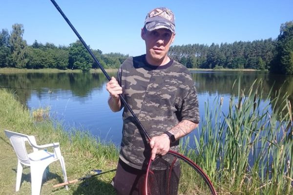 Mieszkaniec stoi z podbierakiem.