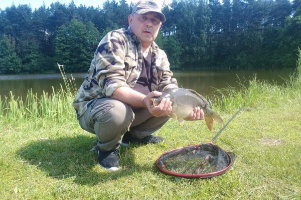 Mieszkaniec kuca z ryba w ręku.