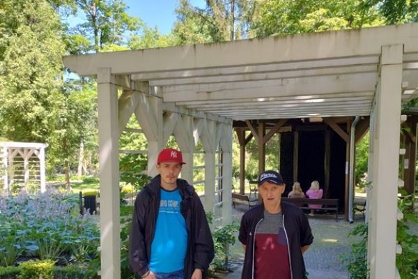 Dwoje mieszkańców  na tle parku.