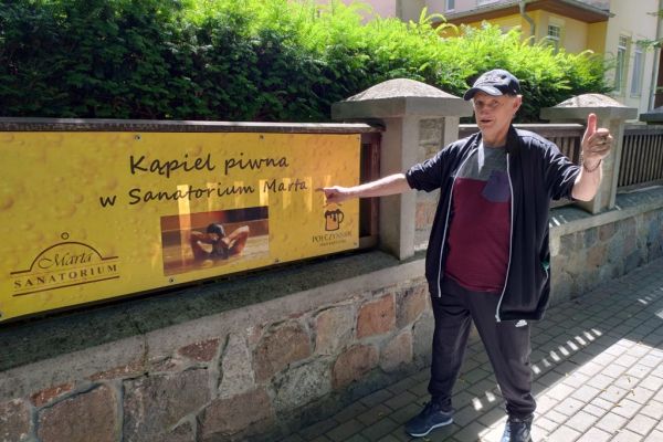 Mieszkaniec przy banerze informacyjnym.