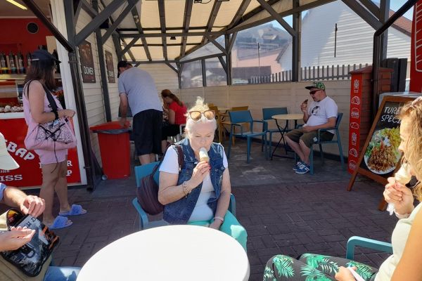 Mieszkańcy jedzą lody.