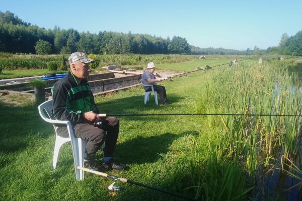 Mieszkaniec siedzi i łowi ryby.