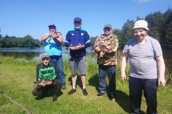 Pięcioro Mieszkańców stoi z połowem w ręku.