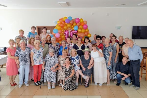 Grupowe zdjęcie seniorów i mieszkańców.