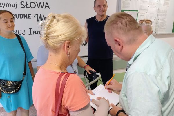 Nasi mieszkańcy przekazuja kopertę mieszkance wioski.